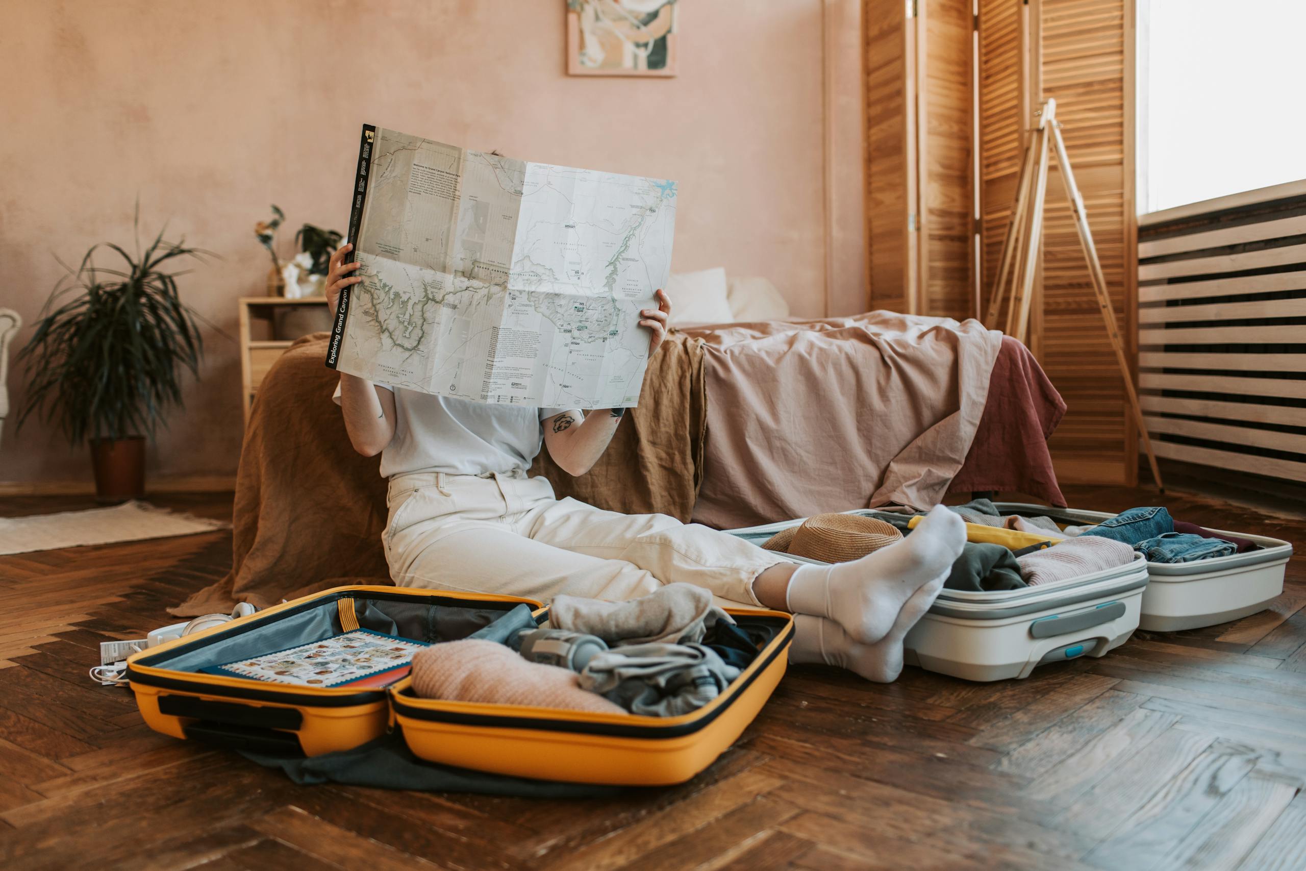 Essential Tips for Minimalist Travel - Person Packing Suitcases With A Map In A Cozy Bedroom Preparing For A Journey. 7368269 Scaled 