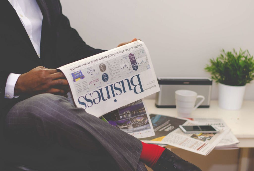 Businessman reading a financial newspaper at a desk, highlighting finance and commerce theme. ClearPulse News