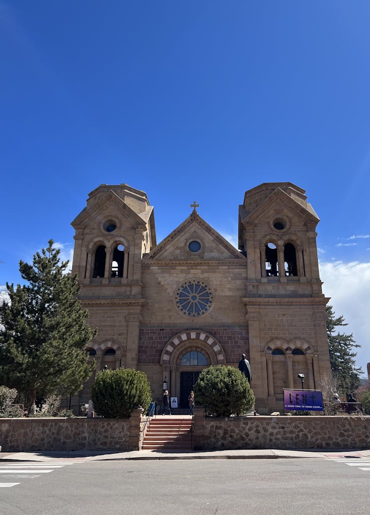 Historic Cathedral Basilica of St. Francis in Santa Fe, New Mexico under a clear blue sky.