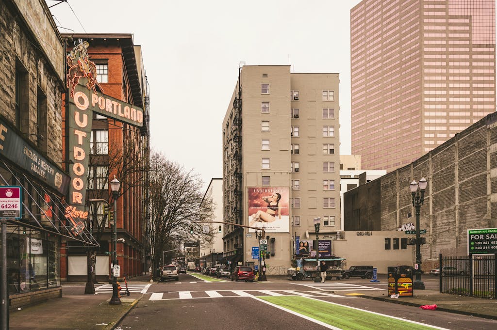 Urban street scene in downtown Portland featuring historic neon sign and modern architecture.